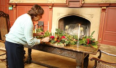 Angie lighting a candle on a Christmas table decoration