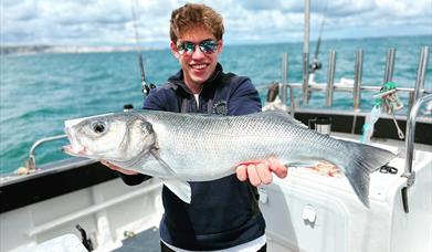 Man holding a fish caught in Swanage Bay with Swanage Sea Fishing