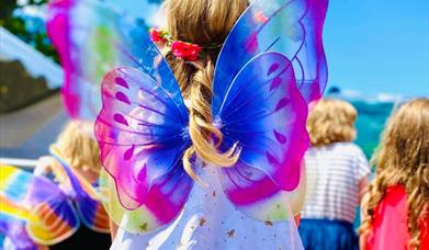 Young girl wearing fairy wings at Swanage Fairy Festival in Dorset