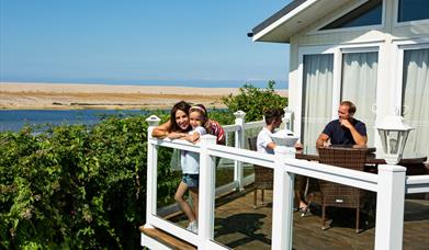 A Family of Four on the Decking of a Coastal Holiday Home