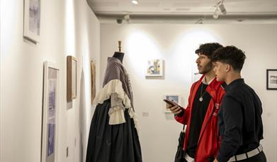 Visitors looking at artwork displayed in the AUB International Collective Exhibition 2024