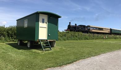 Shepherd's Hut and Swanage Railway steam train at Woodyhyde Campsite in Dorset