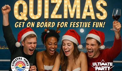 two men and two women dressed in santa hats playing a quiz and the men are cheering