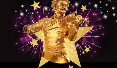 A golden statue of composer Johann Strauss II, surrounded by stars