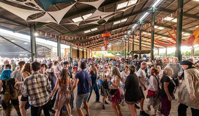 A group of people dancing in a barn with festival decorations