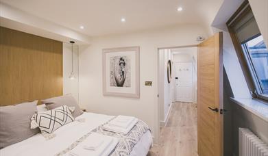 Contemporary master bedroom, with king-size bed, luxury linen and en-suite shower room.