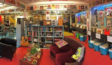 Clocktower records Bridport - a colourful photo of the interior of the shop showing a large selection of preloved and new vinyl, CDs and cassettes for