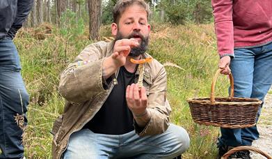 Andy foraging for mushrooms and showing the audience his findings