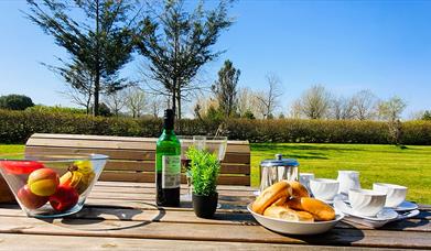 Picnic tables for dining outside with wine and nibbles to enjoy while socialising