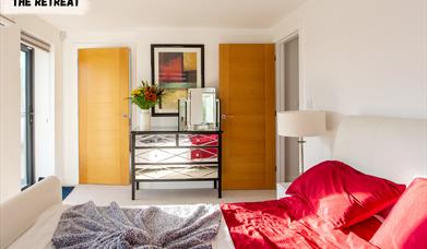 Cosy bedroom with plush bedding in The Retreat, a luxury Dorset escape.