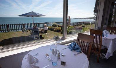 Dine at the Pines in the dining room or on the terrace with panoramic seaviews across the lawn.